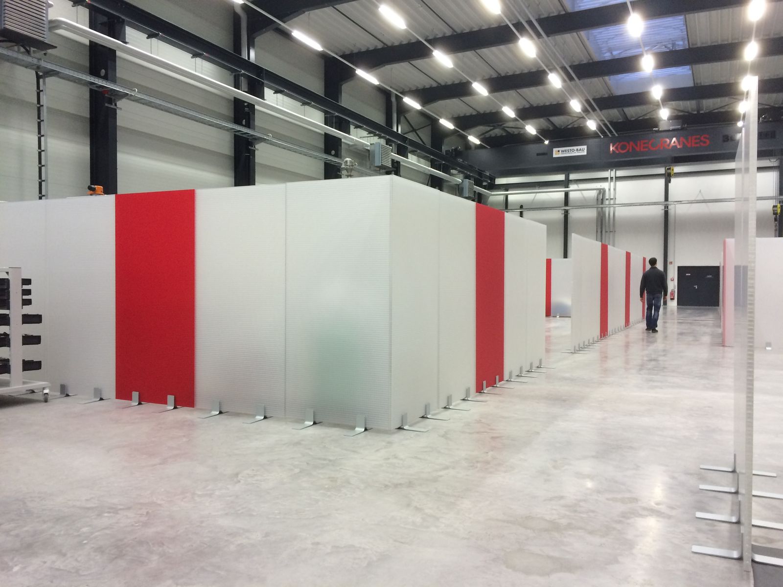 Mobile Schallschutzwände auf Standfüßen grenzen Arbeitsbereiche in einer Montagehalle ab