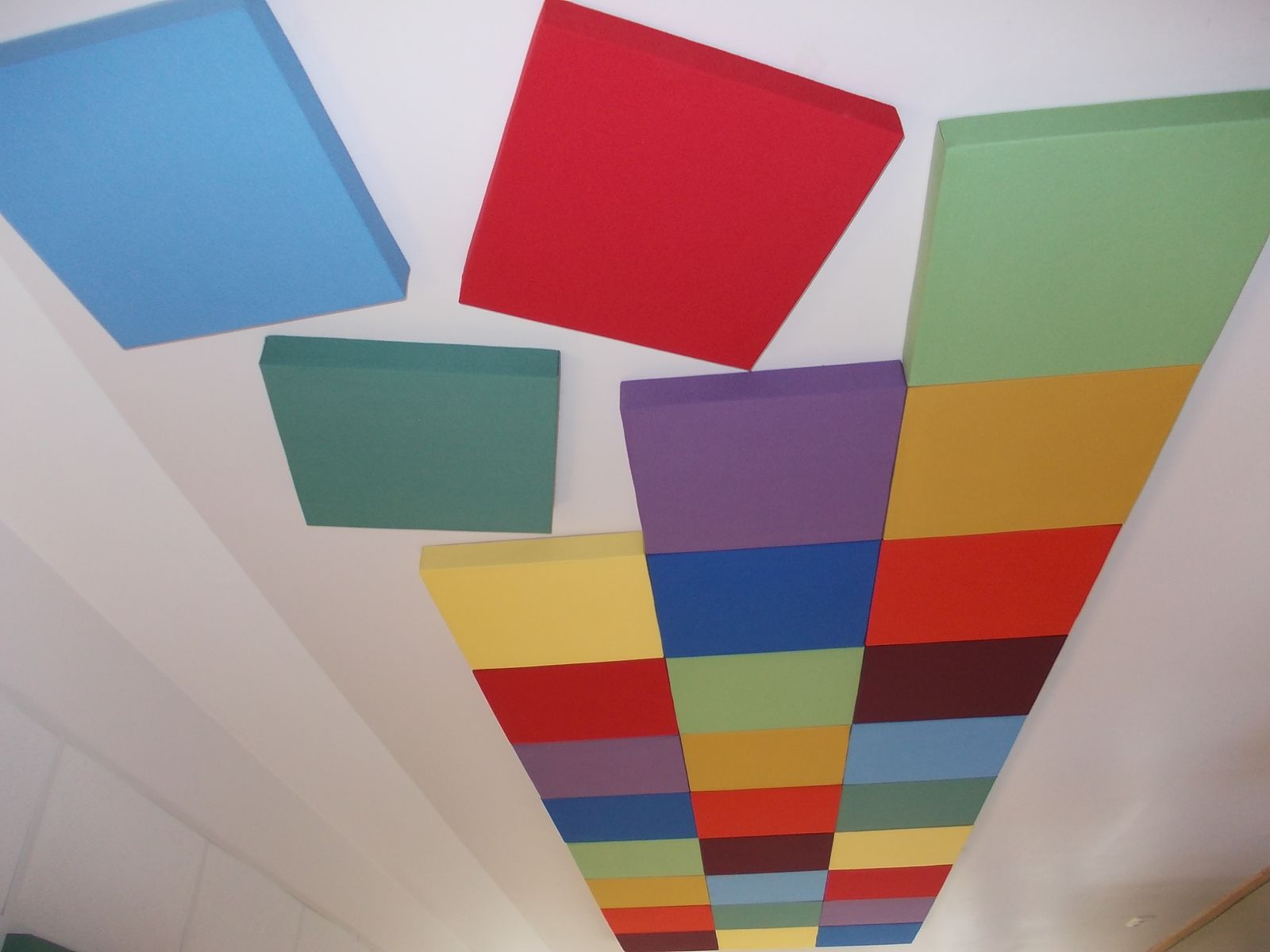 Versetzt montierte Breitbandabsorber in kräftigen Farben an der Wand